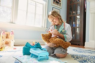 Portrait of Amazing Patient Lyla Grondin playing with a stuffed animal