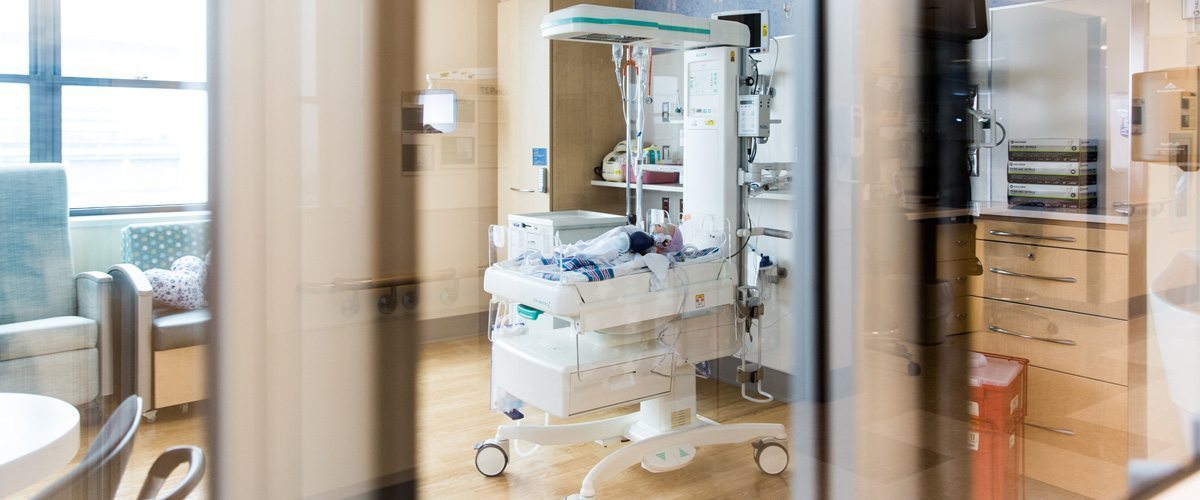 An infant patient on a small gurney in a hospital room