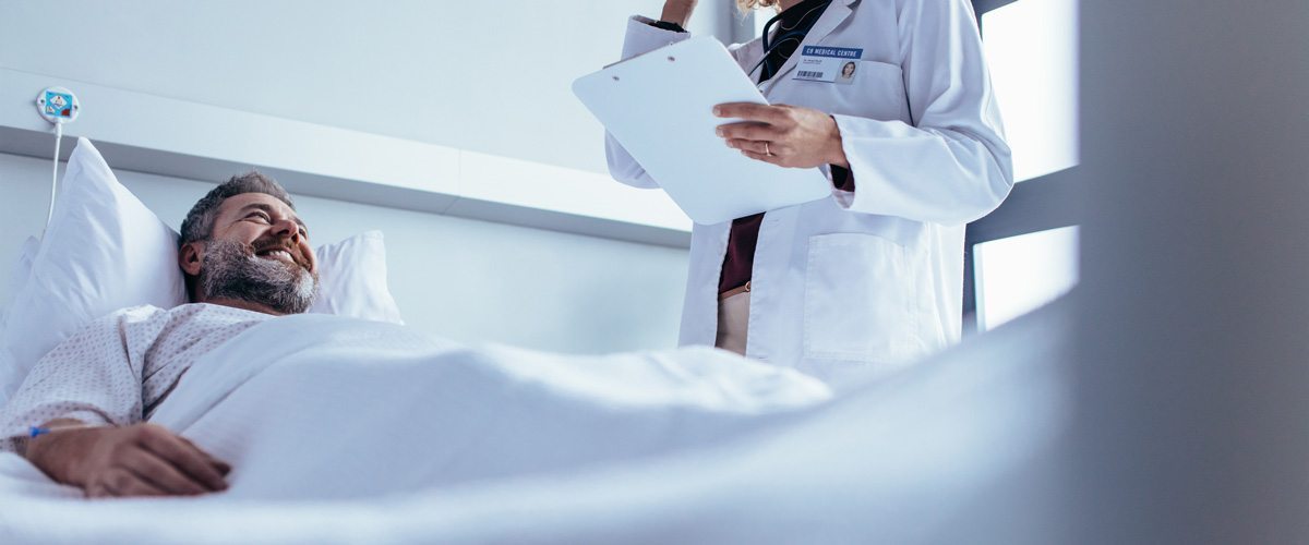 A man listening to a healthcare provider from his hospital bed