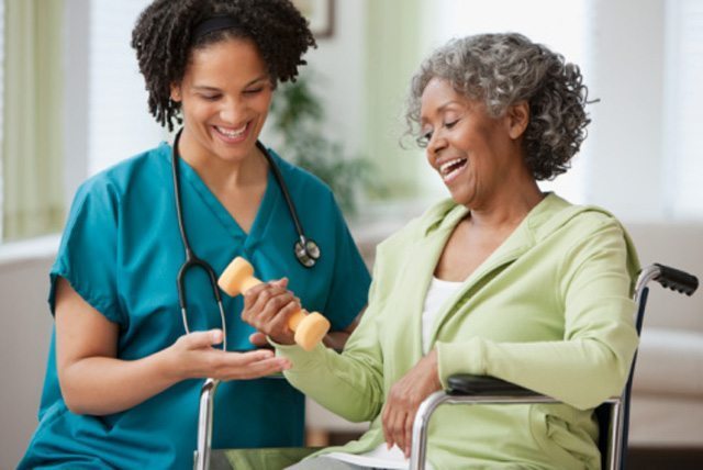 A woman in a wheelchair learning how to use a hand weight