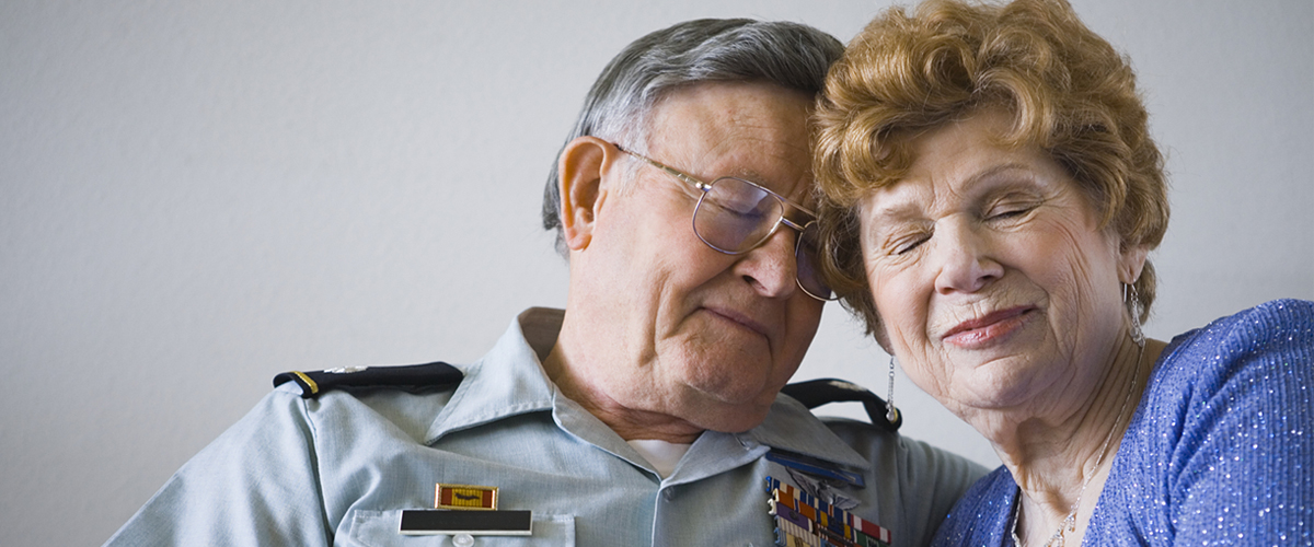 Elderly war veteran with wife.
