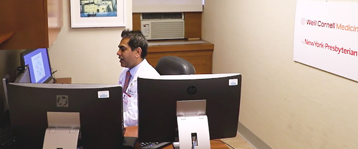 Dr. Rahul Sharma in front of a computer screen for a virtual healthcare visit