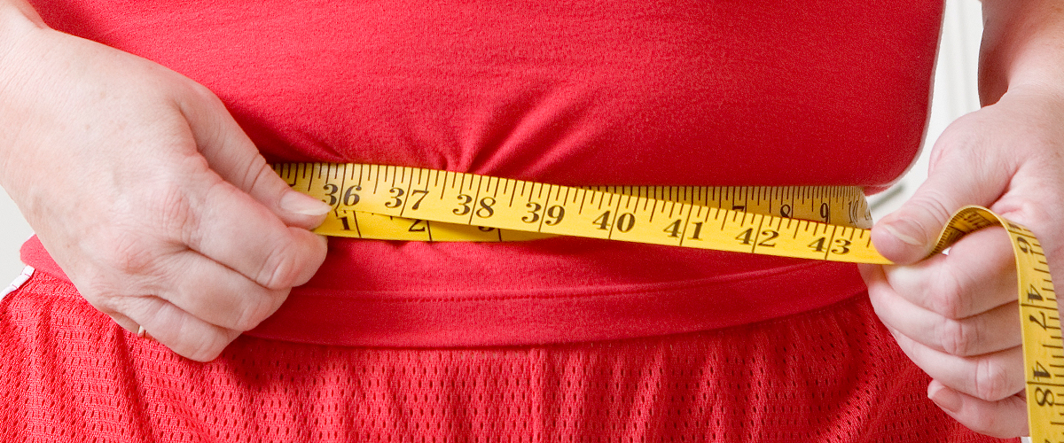 woman measuring waistline