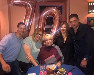 A woman poses with her adult children
